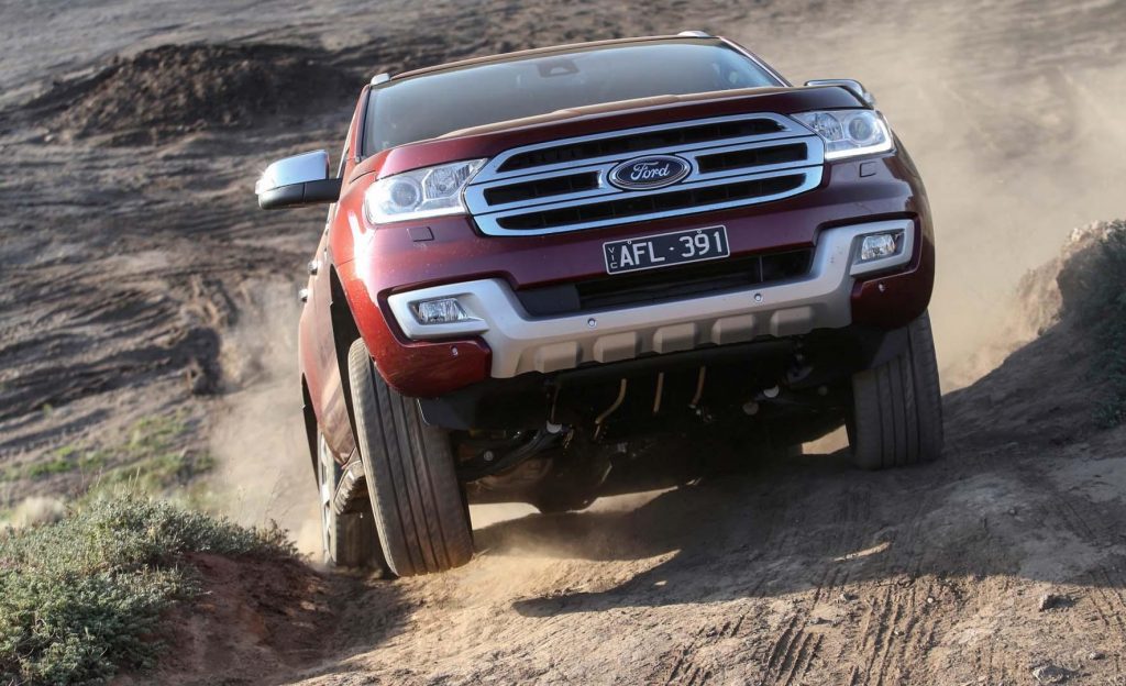 A red Ford Endeavour driving uphill